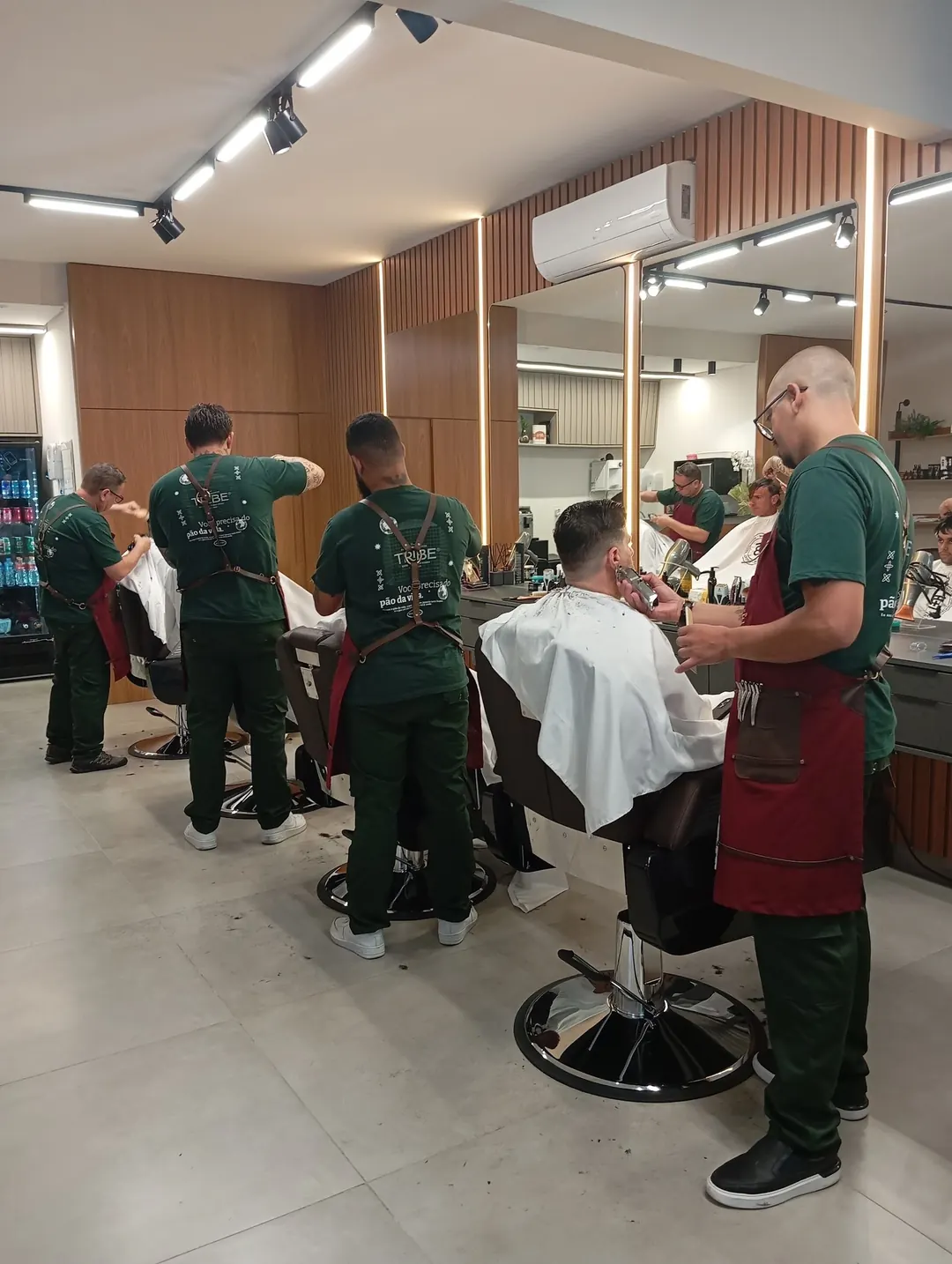 Barbeiros da Tribe atendendo clientes no salão da unidade de Taubaté